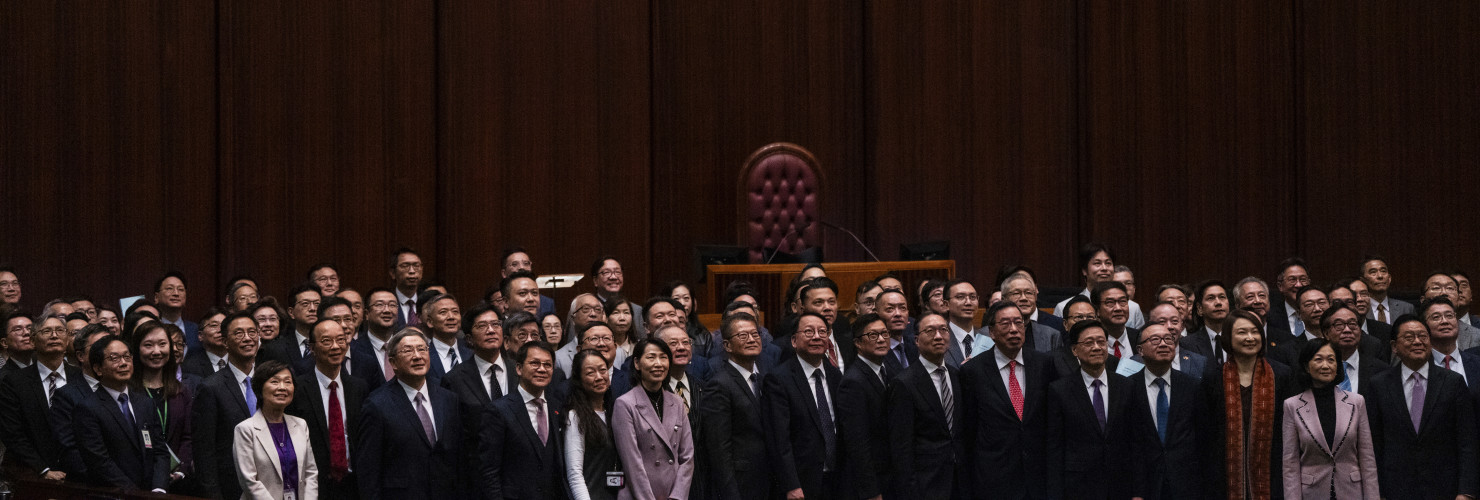 Hong Kong's Chief Executive John Lee, fifth foreground left, pose for photographs with lawmakers following the passing of the Basic Law Article 23 legislation at the Legislative Council in Hong Kong, Tuesday, March 19, 2024. 