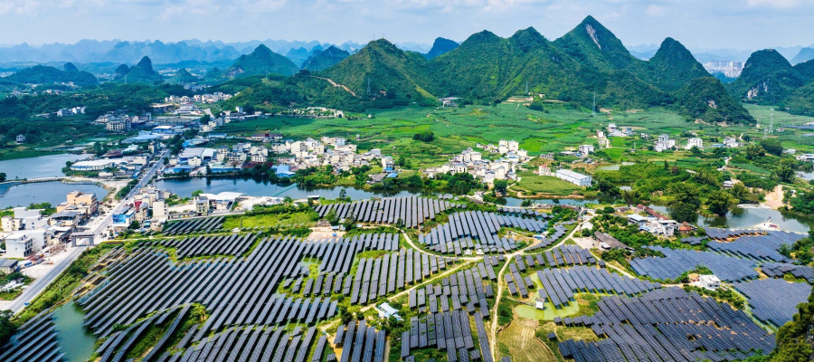 A vast array of deep-blue solar panels stretches across karst mountains at the Hongqi photovoltaic power base in Dahua Yao Autonomous County, Hechi, south China's Guangxi Zhuang Autonomous Region, Sept. 9, 2026, blending with scattered homes and farmland. (Photo by Imaginechina/Sipa USA)