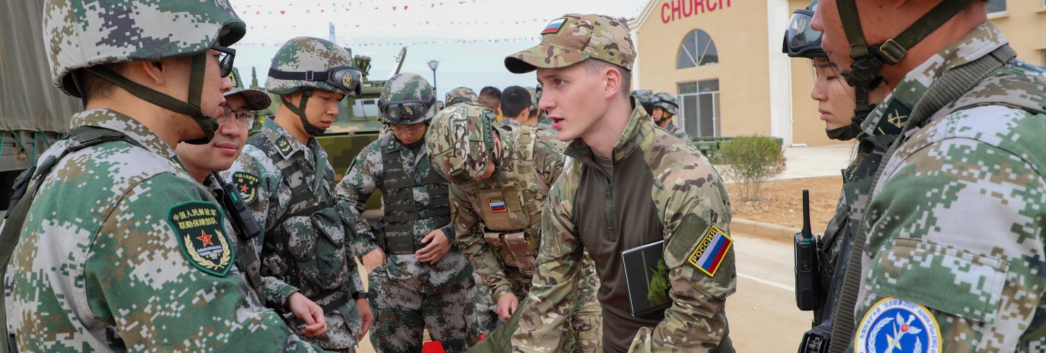 Chinese and Russian soldiers communicate with each other during a joint exercise