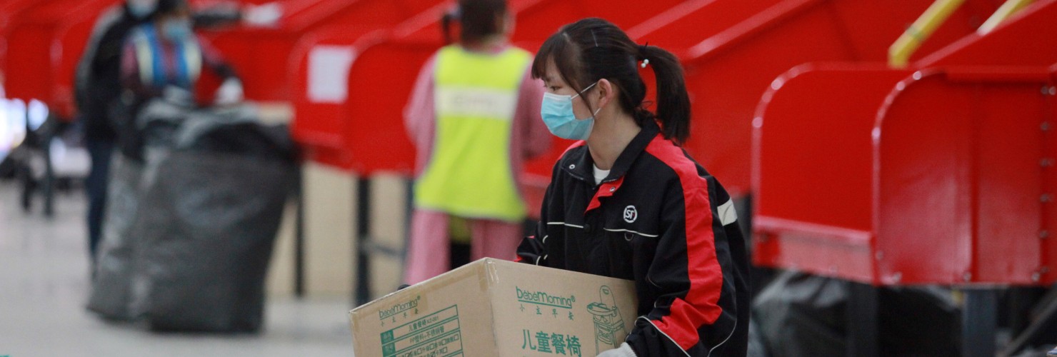 Workers sort packages at the transfer site of a Courier company in Guangling District, Yangzhou City