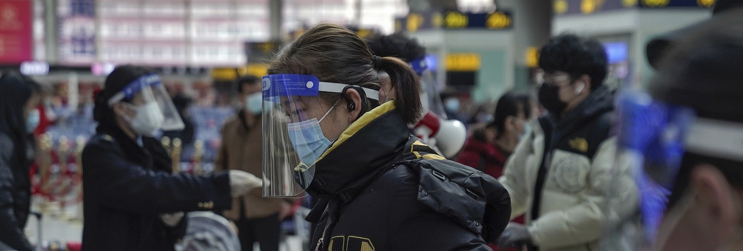 Woman with face mask and shield at South Train Station in Beijing, Jan 2021