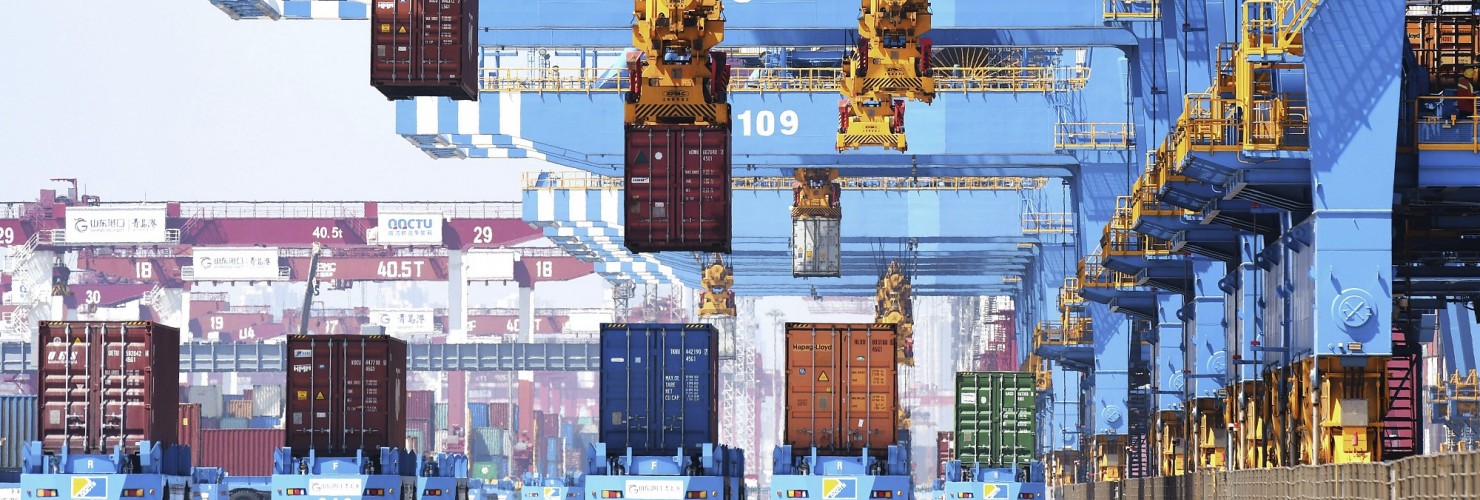 Gantry cranes move containers onto transporters at a port in Qingdao in eastern China's Shandong province.
