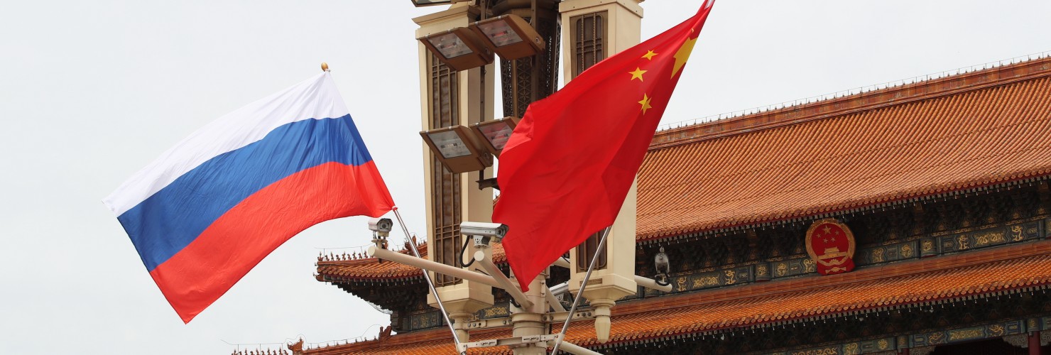 Chinese and Russian national flags flutter on a lamppost in front of the Tian'anmen Rostrum