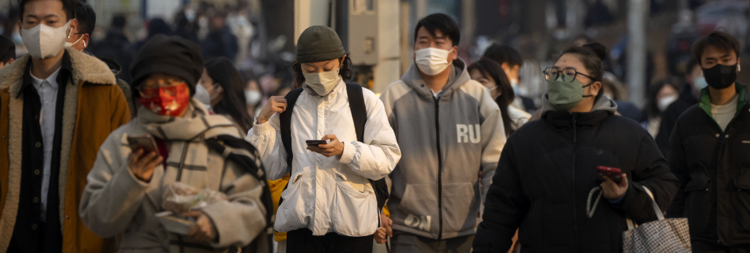 Commuters wearing face masks walk along a street during the morning rush hour in the central business district in Beijing, Thursday, Feb. 16, 2023.