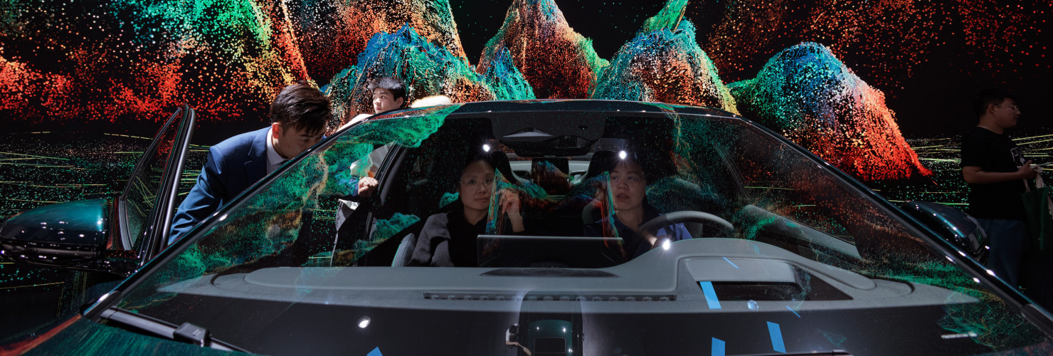 People sit in an EV car standing on display at the BYD company booth, during the second press day of the 20th Shanghai International Automobile Industry Exhibition, in Shanghai, China, 19 April 2023. 