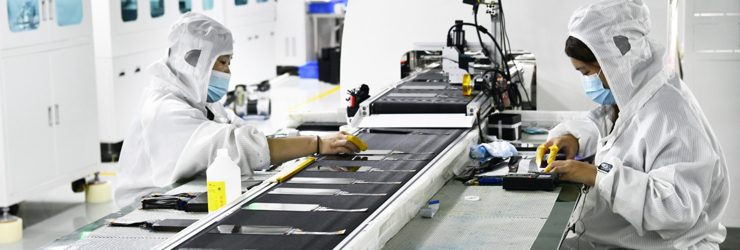 Workers at a liquid crystal display manufacturer work at Shanting Economic Development Zone in east China's Shandong province