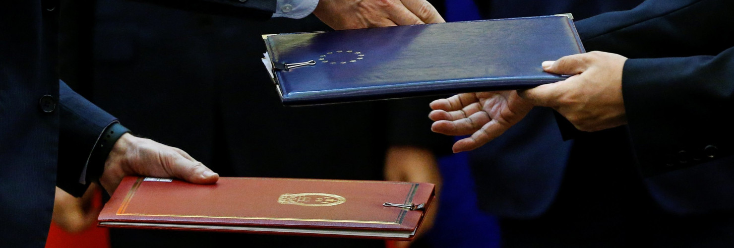Chinese and European officials exchange documents.