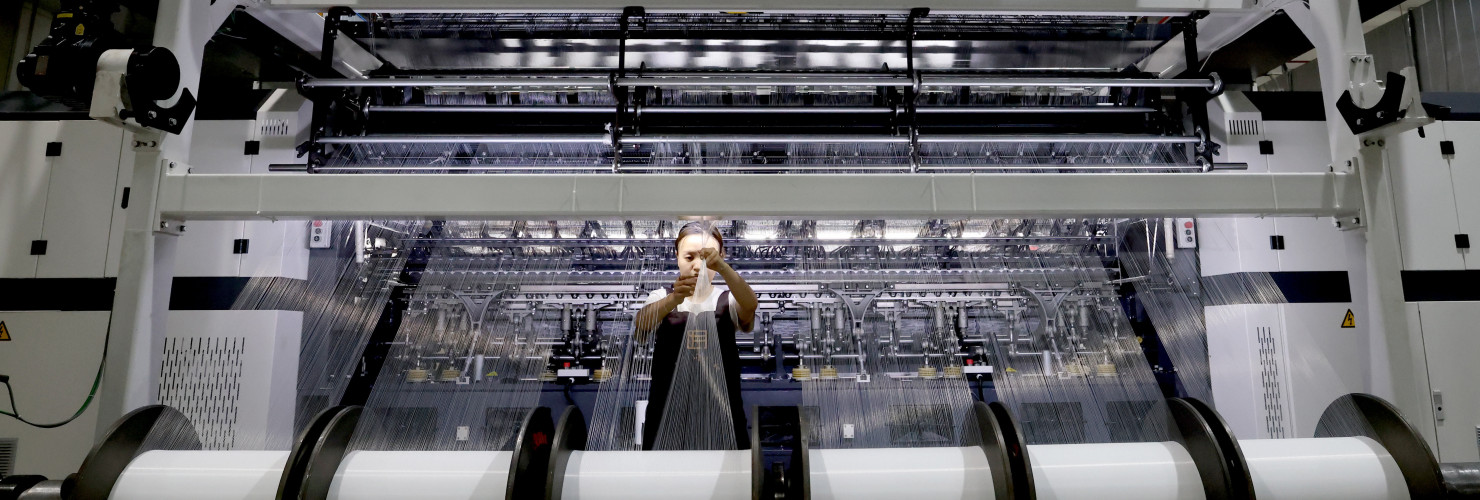 A worker makes lace products on a production line at a smart textile production workshop in Fuzhou, Fujian province, China, Sept 20, 2024.
