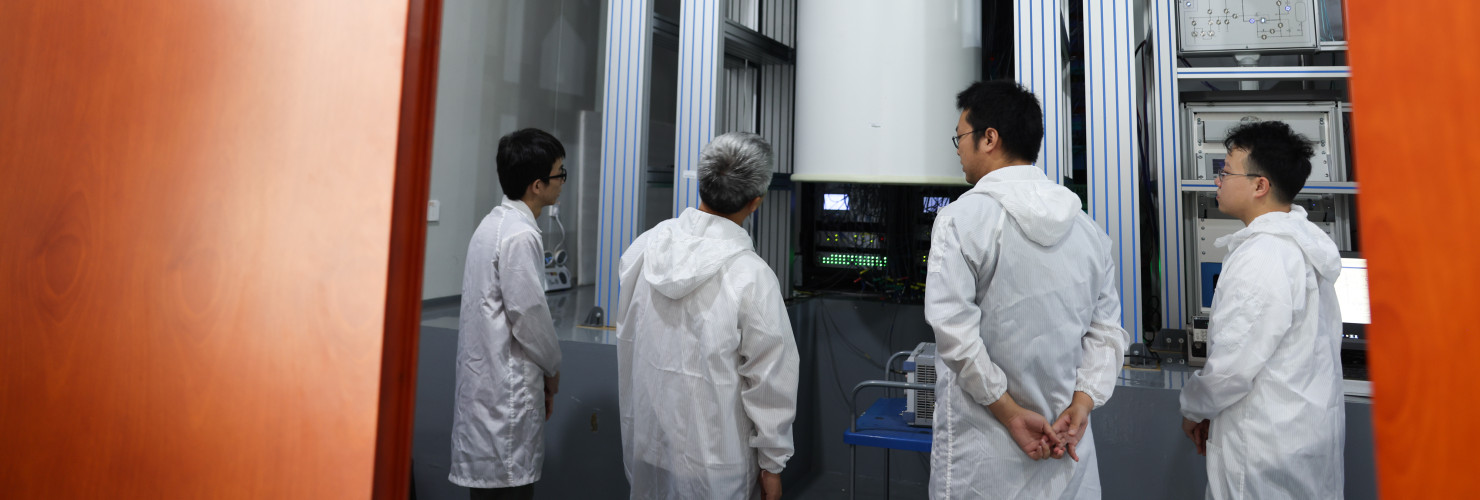 Peng Chengzhi (2nd L) and his colleagues talk about their research in front of the Zuchongzhi 2, a 66-qubit programmable quantum computing system, in Shanghai Research Center for Quantum Science in east China's Shanghai, July 22, 2023.