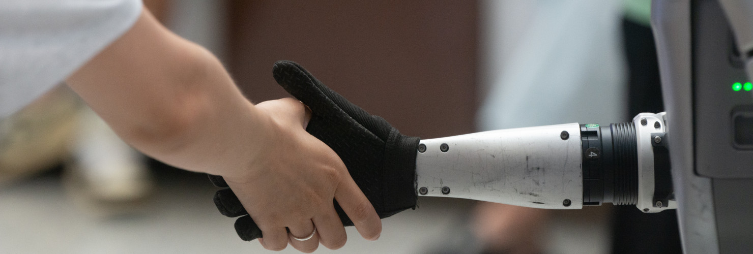 A general view shows a handshake between a human and a humanoid robot at the Shanghai New Expo Center during the opening day of the World Artificial Intelligence Conference (WAIC) 2025 in Shanghai, China, on July 26, 2025.