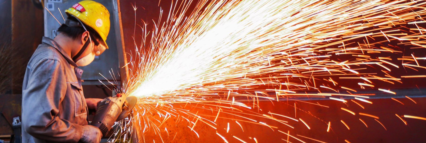A worker is producing wind turbine towers in a workshop of a wind power equipment enterprise in Lianyungang Economic and Technological Development Zone, Jiangsu Province, China