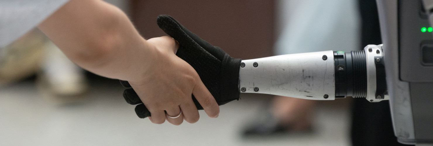 A general view shows a handshake between a human and a humanoid robot at the Shanghai New Expo Center during the opening day of the World Artificial Intelligence Conference (WAIC) 2025 in Shanghai, China, on July 26, 2025.