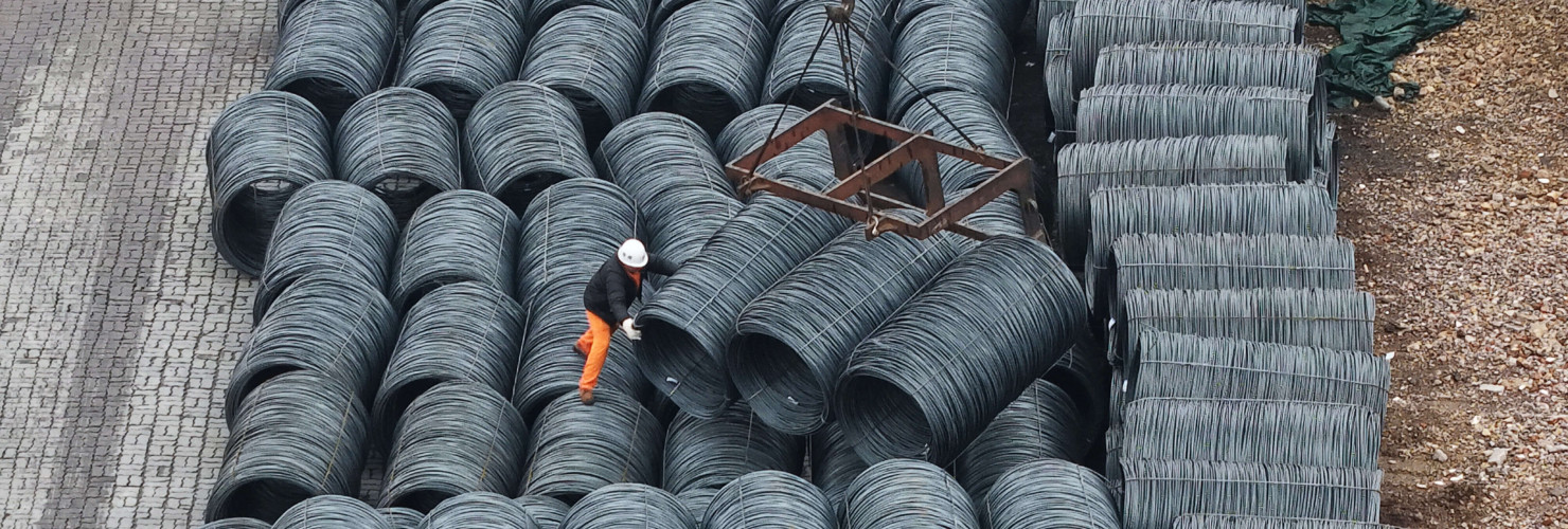 Steel is hoisted and stacked at a steel market in Hangzhou, Zhejiang province
