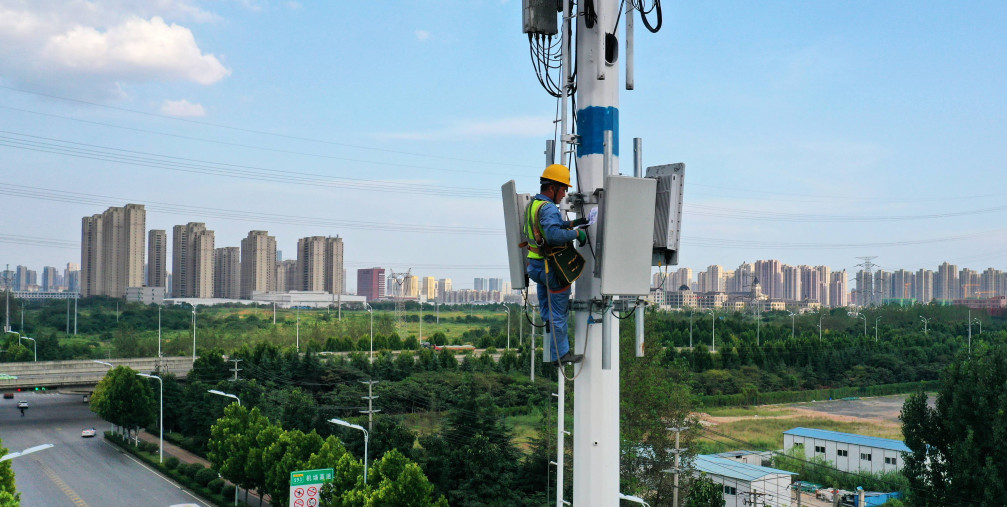 An employee of China Mobile Communications Group checks a 5G base station tower