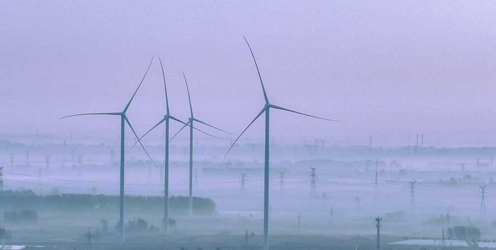 Wind turbines rotate as the sun rises in Zhengji village, Suqian City, Jiangsu Province, China, October 25, 2023.