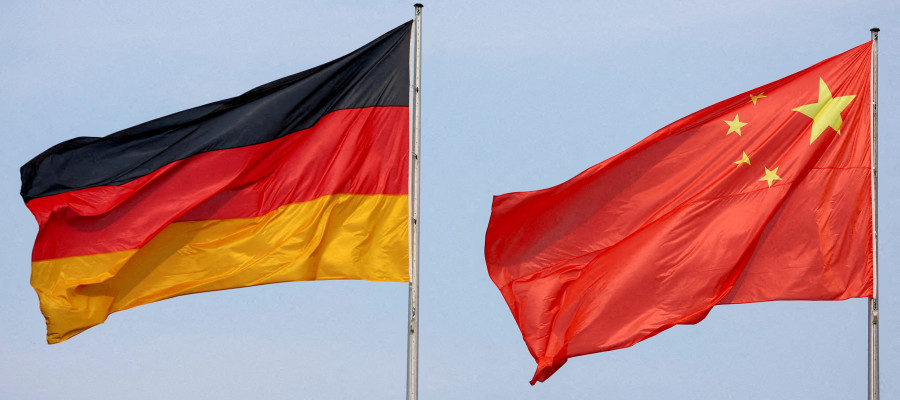 The flags of Germany and China are flying in the wind.