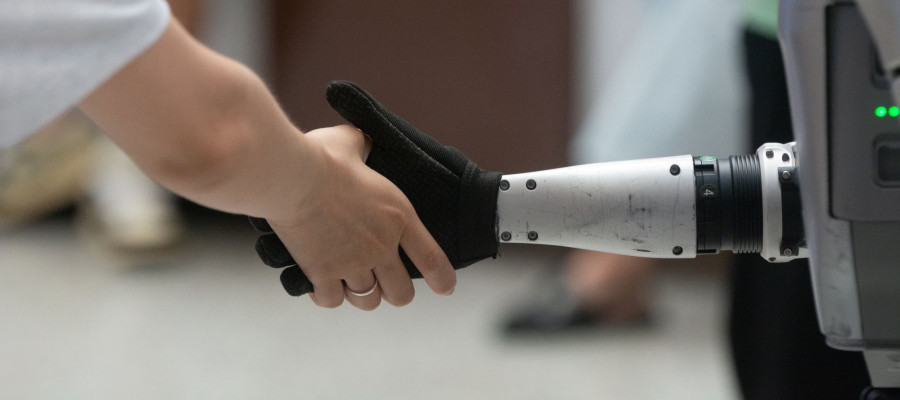 A general view shows a handshake between a human and a humanoid robot at the Shanghai New Expo Center during the opening day of the World Artificial Intelligence Conference (WAIC) 2025 in Shanghai, China, on July 26, 2025.