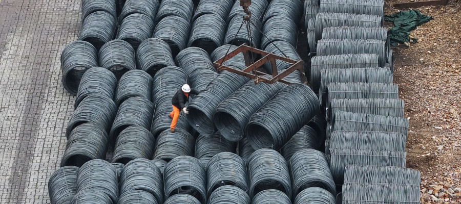 Steel is hoisted and stacked at a steel market in Hangzhou, Zhejiang province