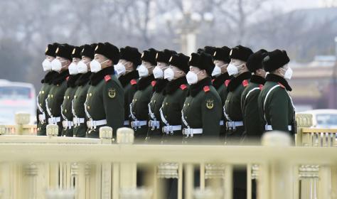 Police officers wearing masks stand guard at Tiananmen Square in Beijing.