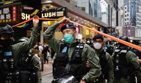 Policeman pass through a cordon line in the city centre on the PRC national day in Hong Kong.