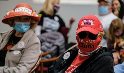 woman wearing a face mask that says, 'I Blame China' awaits the arrival of Tiffany Trump
