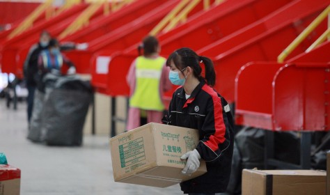 Workers sort packages at the transfer site of a Courier company in Guangling District, Yangzhou City