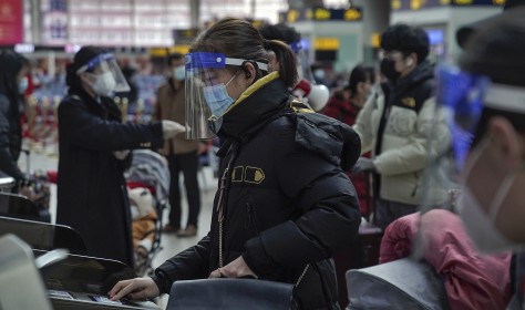 Woman with face mask and shield at South Train Station in Beijing, Jan 2021