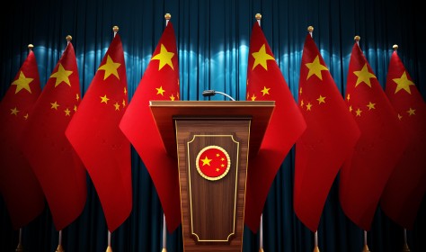 Group of Chinese flags standing next to lectern in the conference hall. 3D illustration. 