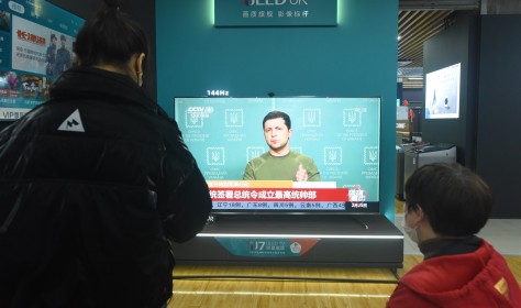 A citizen watches a news report on the conflict between Russia and Ukraine at an appliance store in Hangzhou, east China's Zhejiang Province, Feb 25, 2022.