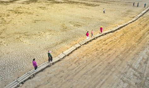 ourists walk on the exposed thousand-hole bridge of the Ming Dynasty in Jiujiang city, East China's Jiangxi province, Sept 3, 2022. As Poyang Lake enters the low and dry season, the thousand-year stone island and the "thousand-hole bridge" on the bed of Poyang Lake are exposed on the dry lake bed.