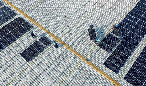 Aerial view of workers installing solar panels on the roof of a plant of China Communications Construction Company (CCCC) Third Harbor Engineering in Zhoushan, Zhejiang Province of China. 