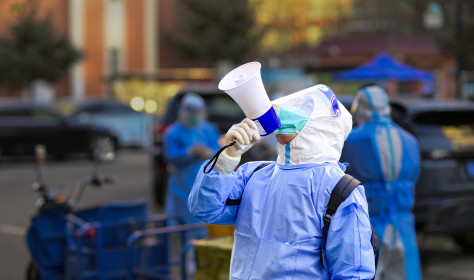 A community worker uses a loudspeaker to organize residents to go downstairs for nucleic acid sampling at a residential community in Hohhot, Inner Mongolia, China, November 15, 2022.