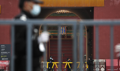 Security guards stand guard at the closed gates of the Forbidden City