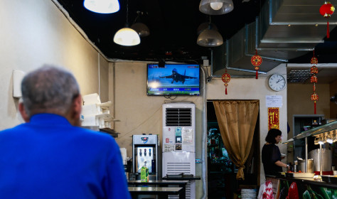 A man watches a TV screen showing a news report of the Chinese live-fire military exercises near Taiwan, at a restaurant in Taipei, Taiwan, on October 22, 2024.