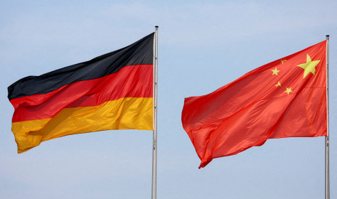 The flags of Germany and China are flying in the wind.