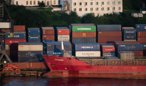 Shipping containers are being loaded onto container ships in the Vladivostok Sea Commercial Port.