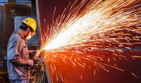 A worker is producing wind turbine towers in a workshop of a wind power equipment enterprise in Lianyungang Economic and Technological Development Zone, Jiangsu Province, China