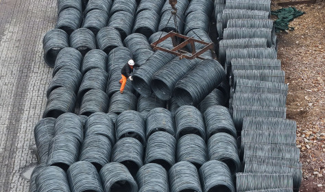 Steel is hoisted and stacked at a steel market in Hangzhou, Zhejiang province