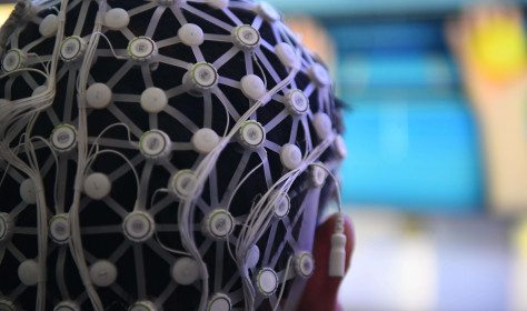 Person demonstrating a motor imagery brain-computer interface rehabilitation training system.