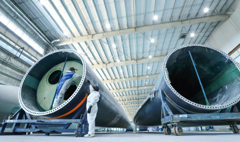 staff member uses intelligent inspection technology to check the quality of fan blades on the inspection line of Shanghai Electric's wind turbine blade production line, located in Nanhua Industrial Park, Gaotai County, Zhangye city, Gansu province, China, March 7, 2024.