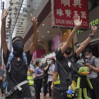 Protesters gesture with five fingers, signifying the "Five demands - not one less" as they march along a downtown street during a pro-democracy protest against Beijing's national security legislation in Hong Kong, Sunday, May 24, 2020. picture alliance / AP Photo