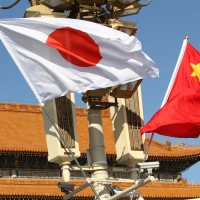 Chinese and Japanese national flags flutter on the lamppost in front of the Tian'anmen Rostrum 