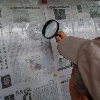 An elderly person reads a newspaper with magnifying glasses that says 'Progress made in the research and development of China's new aircraft carrier' in Beijing, China, 04 August 2022.