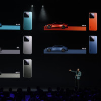 Xiaomi founder Lei Jun shows off the colours of the SU7, a sporty four-door sedan, with matching Xiaomi smartphones in Beijing, Thursday, March 28, 2024. 