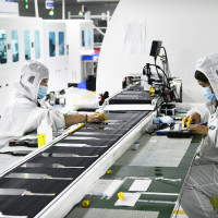 Workers at a liquid crystal display manufacturer work at Shanting Economic Development Zone in east China's Shandong province