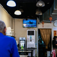 A man watches a TV screen showing a news report of the Chinese live-fire military exercises near Taiwan, at a restaurant in Taipei, Taiwan, on October 22, 2024.