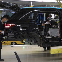 Workers assemble cars at a Beijing Benz Automotive Co. Ltd factory, a German joint venture company for Mercedes-Benz, in Beijing