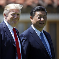 In this April 7, 2017, file photo President Donald Trump and Chinese President Xi Jinping walk together after their meetings at Mar-a-Lago.
