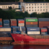 Shipping containers are being loaded onto container ships in the Vladivostok Sea Commercial Port.