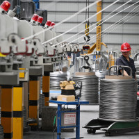  A worker produces bonding wire for domestic and international markets at a workshop in Jiangsu.